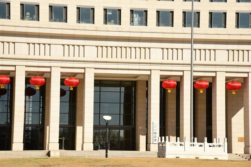 A government building with a modern architectural design, featuring large glass windows and several red lanterns hanging from the eaves.